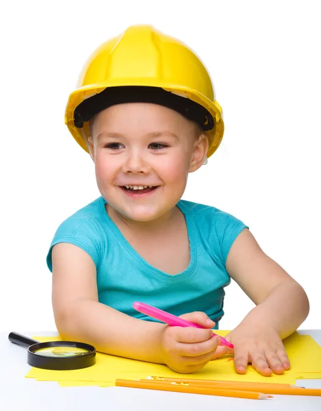 Niedliche kleine Mädchen zeichnen mit Filzstift tragen harten Hut — Stockfoto
