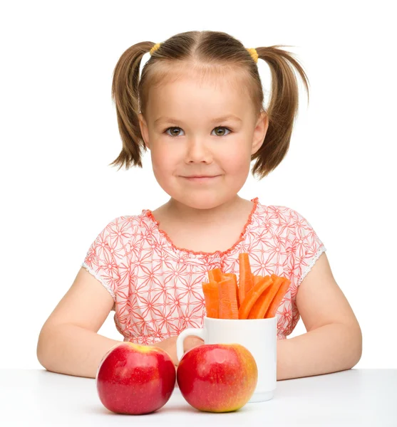 Aranyos kislány eszik, sárgarépa és Alma — Stock Fotó