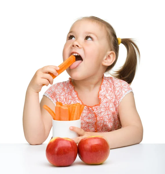 Nettes kleines Mädchen isst Karotten und Äpfel — Stockfoto