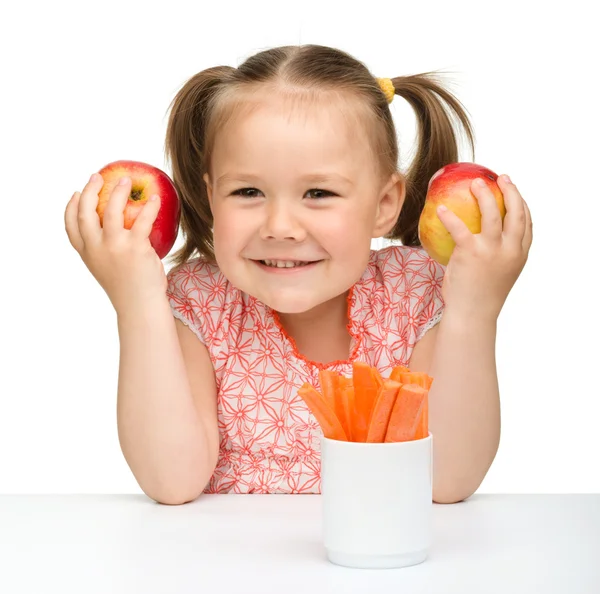 Aranyos kislány eszik, sárgarépa és Alma — Stock Fotó