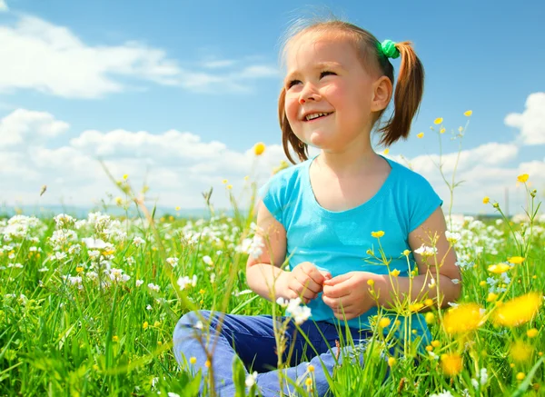 Petite fille joue sur la prairie verte — Photo