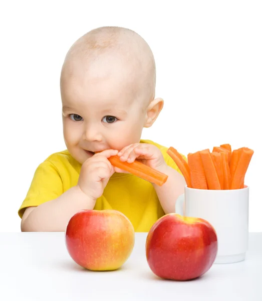 Carino ragazzino mangia carote e mele — Foto Stock