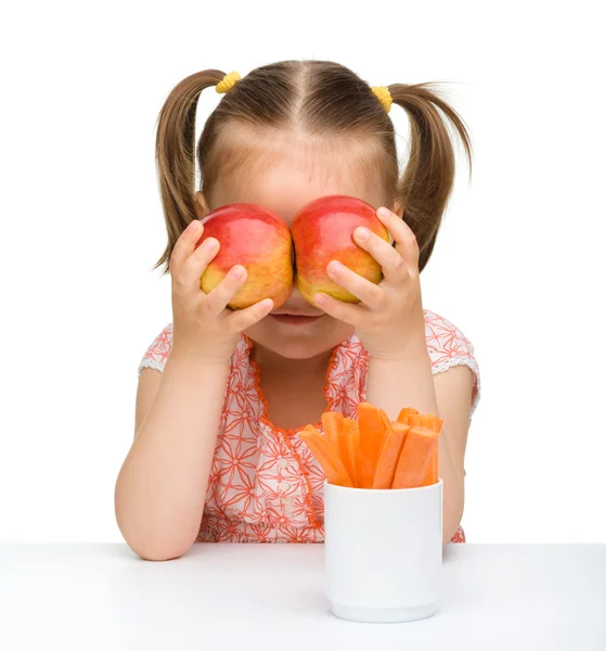 Schattig klein meisje met wortel en appels — Stockfoto