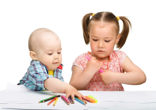 Zwei Kinder zeichnen mit Filzstiften auf Papier — Stockfoto