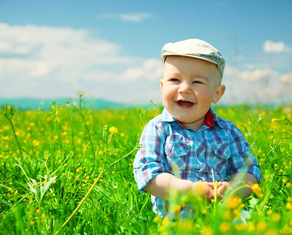 Kleine jongen speelt op groene weide — Stockfoto