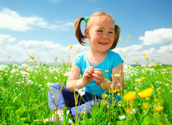 Mała dziewczynka bawi się na zielony łąka — Zdjęcie stockowe
