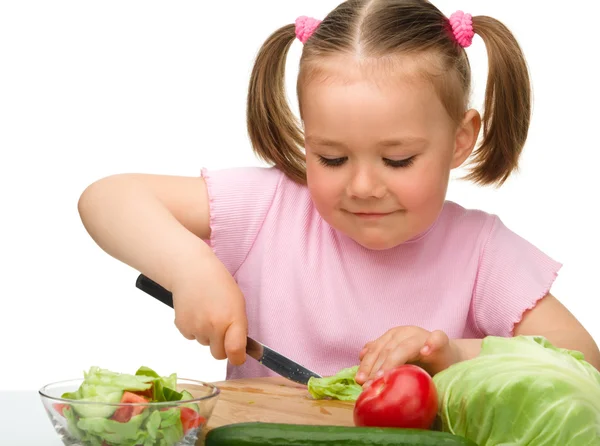 Menina está cortando cenoura para salada — Fotografia de Stock