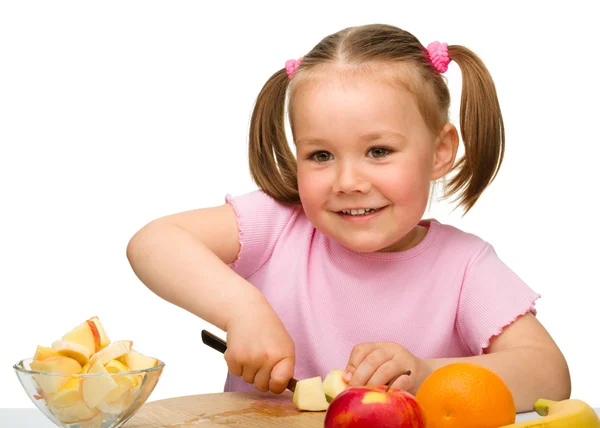 小さな女の子がサラダの果物を切って — ストック写真