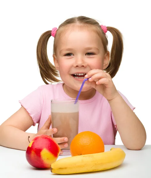 Malá holka pije ovocné šťávy — Stock fotografie