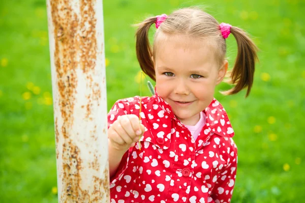 Kleines Mädchen spielt auf grüner Wiese — Stockfoto