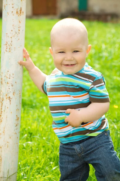 Kleine jongen speelt op groene weide — Stockfoto