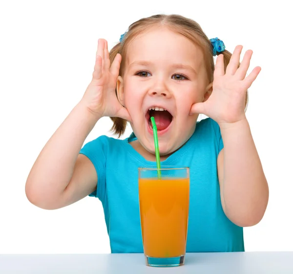Malá holka pije pomerančovou šťávu — Stock fotografie