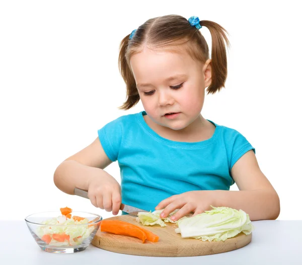 Petite fille coupe la carotte pour la salade — Photo