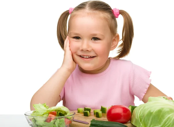 Kleines Mädchen schneidet Möhre für Salat — Stockfoto