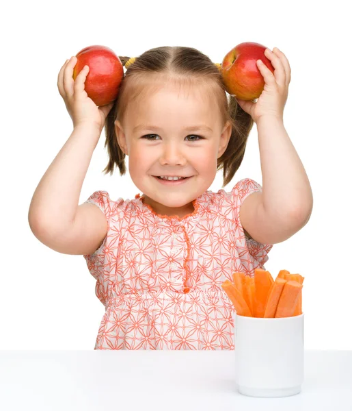 かわいい女の子はニンジンとリンゴを食べる — ストック写真
