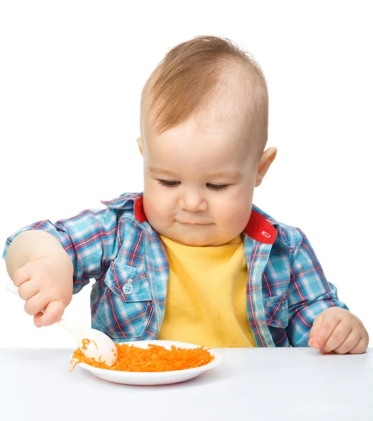 Söt liten pojke leker med morot sallad — Stockfoto
