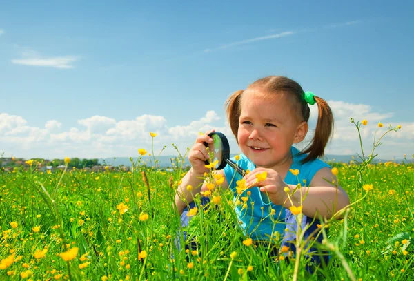 Bambina esaminando fiori utilizzando lente di ingrandimento — Foto Stock