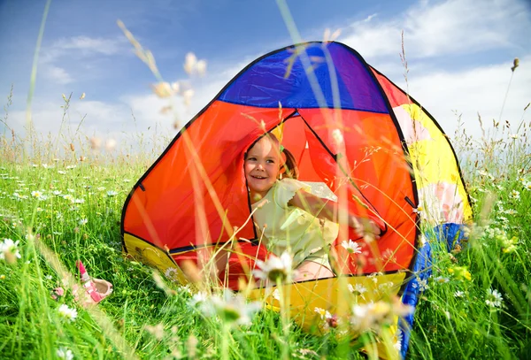 Girl is playing outdoors under tent — Stock Photo, Image