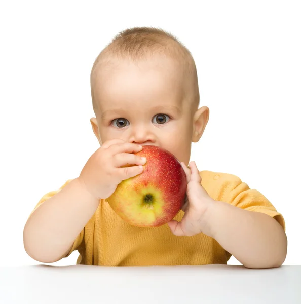 小さな子供は赤いりんごを噛んでください。 — ストック写真