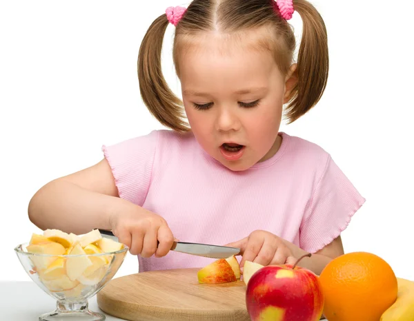 Menina está cortando frutas para salada — Fotografia de Stock