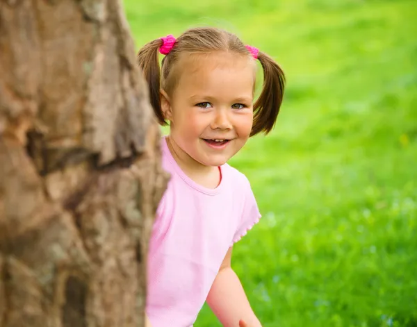 Malá holčička se hraje na schovávanou venku — Stock fotografie