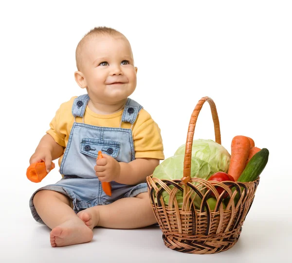 Cute little boy with basket full of vegetables — Stock Photo, Image