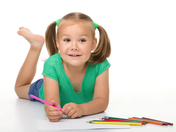 小さな女の子が床の上を敷設しながら描画します。 — ストック写真