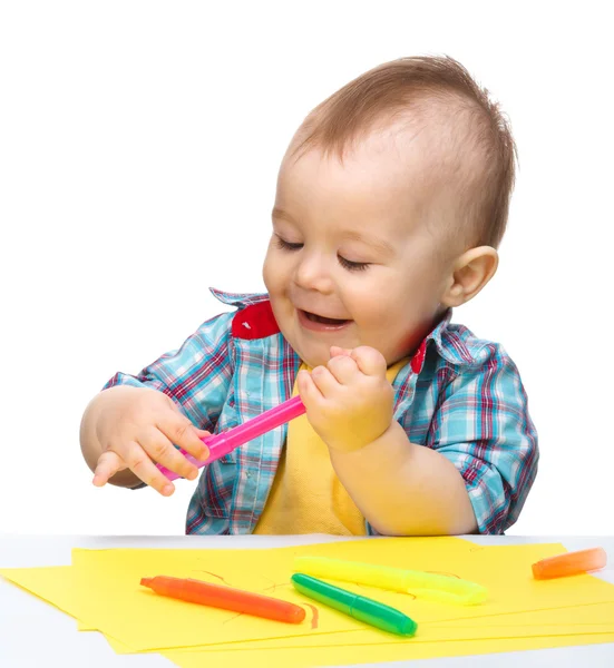 Menino feliz está brincando com marcadores coloridos — Fotografia de Stock