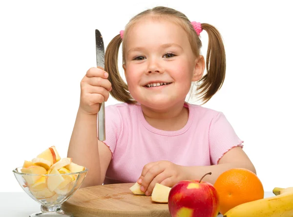 Klein meisje is snijden vruchten voor salade — Stockfoto