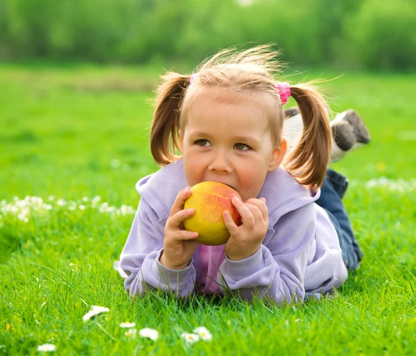 Little girl is laying on green meadow — Stock Photo, Image
