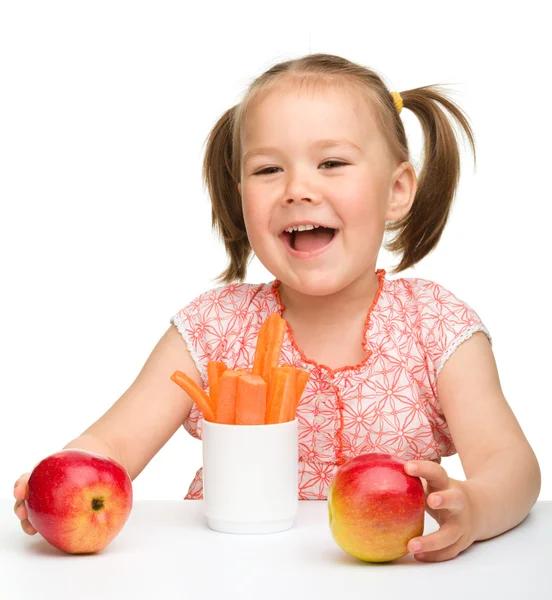 Linda niña come zanahoria y manzanas — Foto de Stock