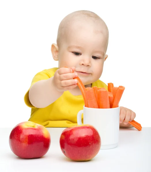 Pequeño niño sacando zanahoria de una taza —  Fotos de Stock