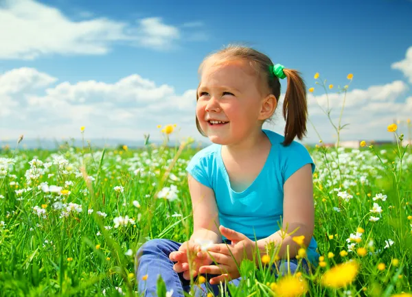 Malá holčička se hraje na zelené louce — Stock fotografie