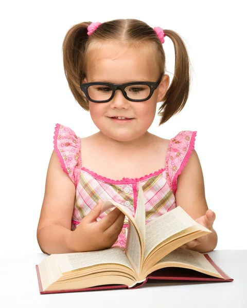 小さな女の子は、本のページをひっくり返す — ストック写真