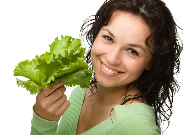 Krásná mladá dívka s zelených salátových listů — Stock fotografie