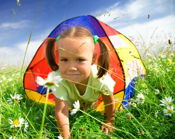 Девушка играет на открытом воздухе под тентом — стоковое фото