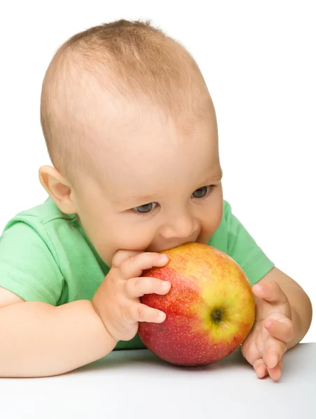 Маленька дитина їсть червоне яблуко — стокове фото