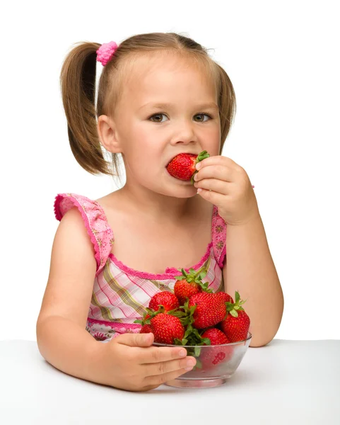 Счастливая маленькая девочка ест клубнику — стоковое фото
