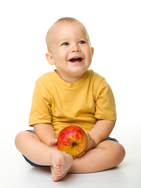 Веселый маленький мальчик с красным яблоком — стоковое фото