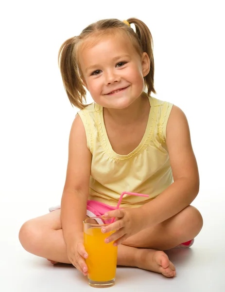 Lilla flickan dricker apelsinjuice — Stockfoto