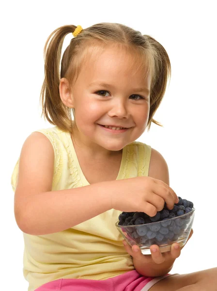 Menina alegre está comendo mirtilo — Fotografia de Stock