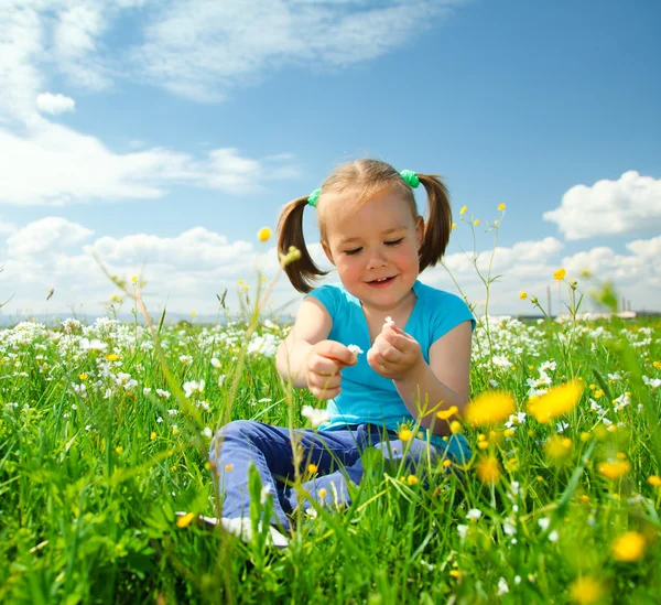 Kleines Mädchen spielt auf grüner Wiese — Stockfoto