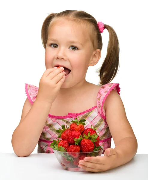 Happy little girl eats strawberries — Stock Photo, Image