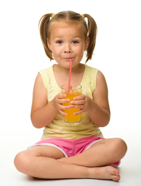 Lilla flickan dricker apelsinjuice — Stockfoto