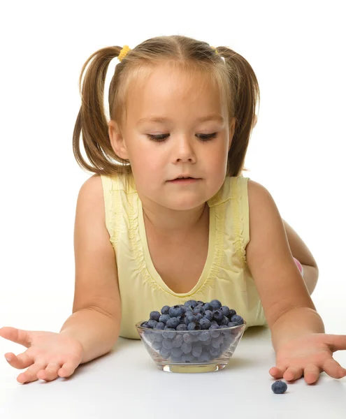 Schattig klein meisje eet bosbessen — Stockfoto