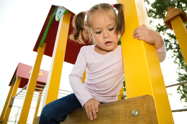 Küçük kız oyun alanında oynuyor — Stok fotoğraf