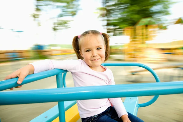 かわいい女の子はメリーゴーランドに乗っています。 — ストック写真