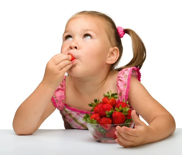 Счастливая маленькая девочка ест клубнику — стоковое фото