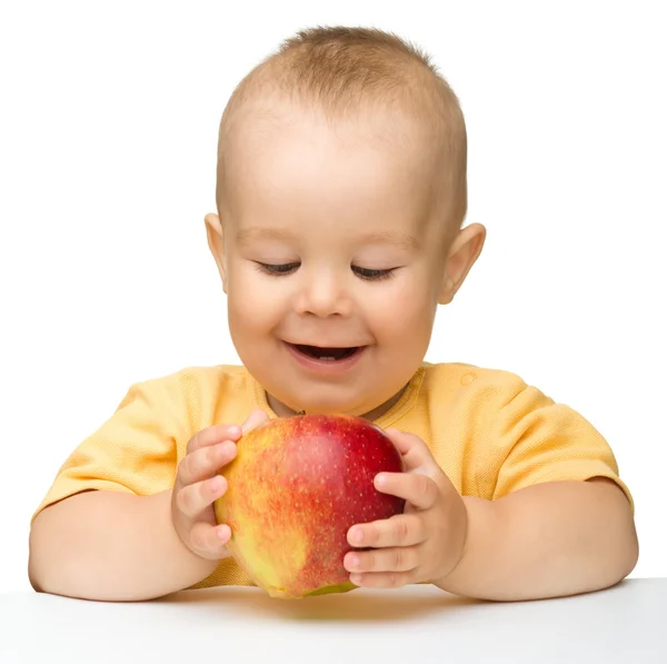 小さな子供は赤いりんごを噛んでください。 — ストック写真