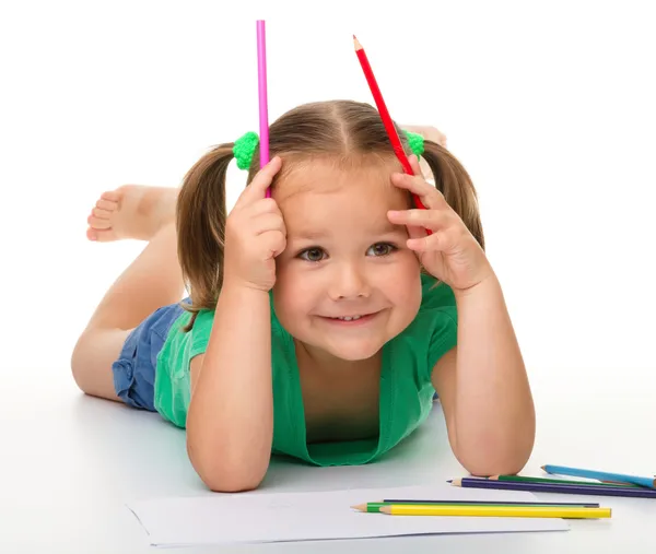 Little girl is drawing while laying on the floor — Stock Photo, Image